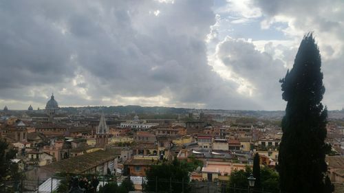 Aerial view of cityscape against cloudy sky