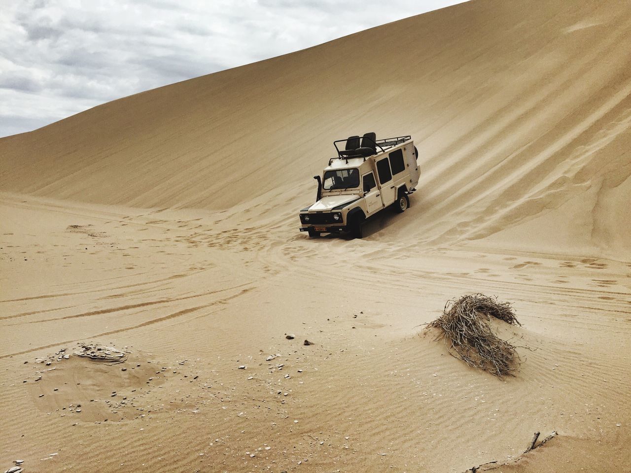 sand, beach, sky, transportation, tranquility, tranquil scene, scenics, desert, mode of transport, shore, nature, landscape, travel, beauty in nature, sand dune, land vehicle, footprint, mountain, sunlight, sea