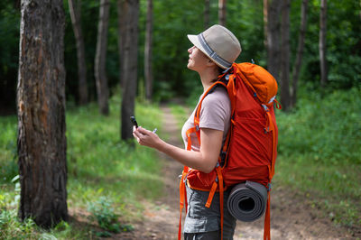 Rear view of young man standing in forest