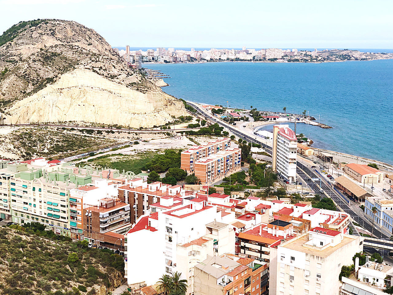 HIGH ANGLE VIEW OF BUILDINGS BY SEA AGAINST SKY