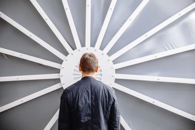 Rear view of man standing against wall