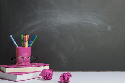 Close-up of pink flower on table against wall