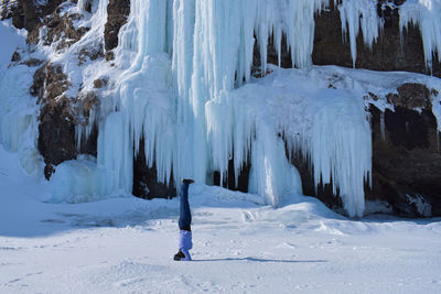 Headstanding on snow covered land