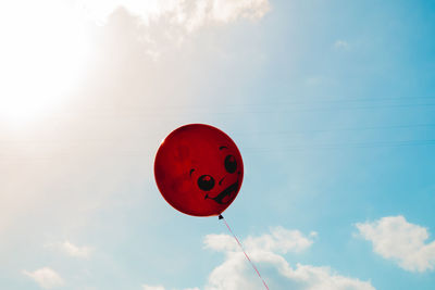 Low angle view of heart shape balloon against sky