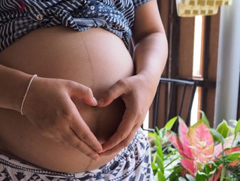 Midsection of woman with pink flowers