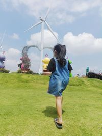 Woman standing on field against sky