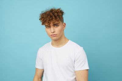 Portrait of young man against blue background