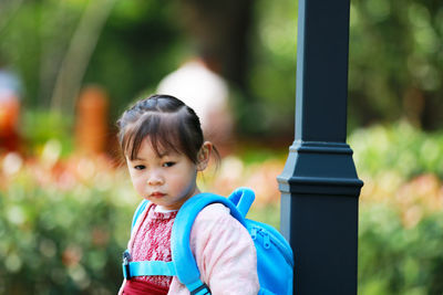 Cute girl looking away while standing in park