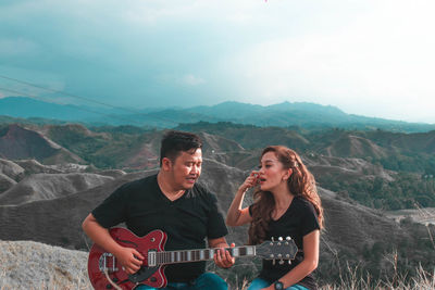 Young couple sitting on mountain