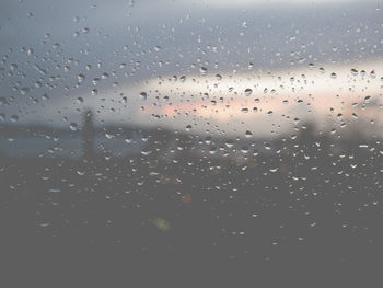 Full frame shot of wet window against sky