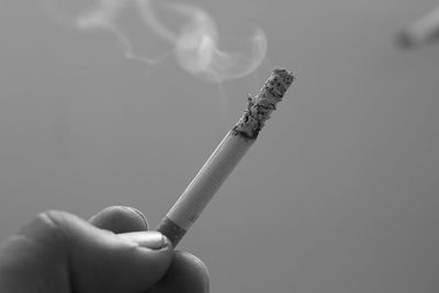 Close-up of hand holding cigarette