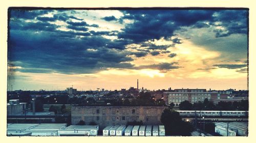 View of cityscape against cloudy sky