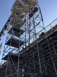 Low angle view of crane and building against sky