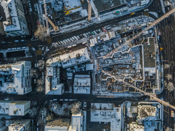 Aerial view of cranes and buildings in city during winter