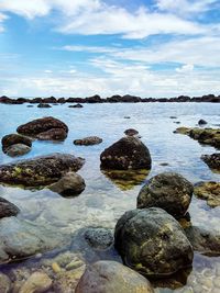Rocks in sea against sky