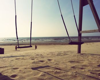 Scenic view of sandy beach against clear sky