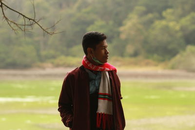 Side view of smiling girl standing on field