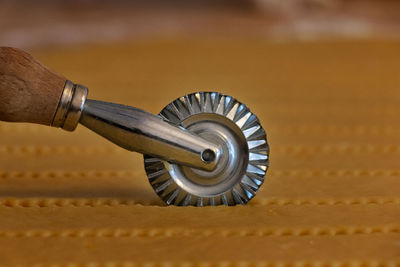 Detail of a steel pastry cutter wheel while cuts a layer of puff pastry