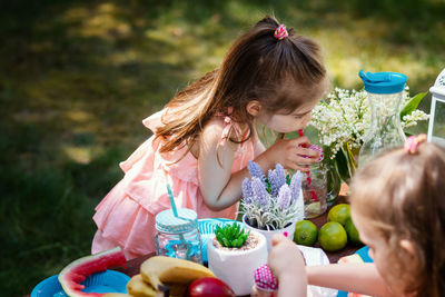 Sisters having food and drink in yard