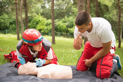 Healthcare workers practicing on cpr dummy at park