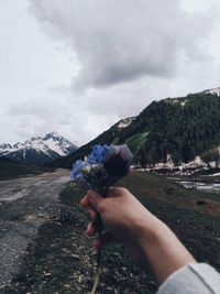 Midsection of person against mountain range against sky