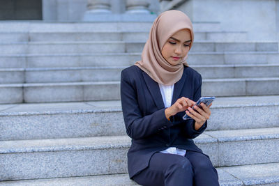 Full length of a woman using mobile phone