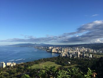 High angle view of city buildings against blue sky