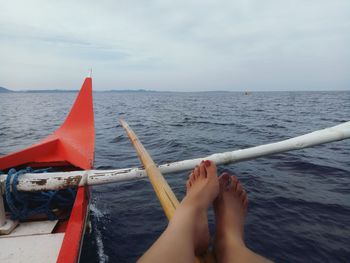 Low section of man on boat against sky