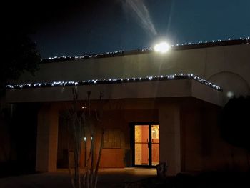 Illuminated street light against sky at night