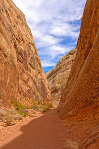 Road leading towards mountains against sky