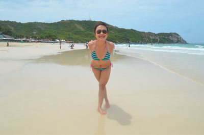 Portrait of young woman standing on beach