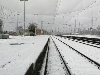 Railroad tracks against sky during winter