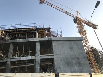 Low angle view of building under construction against sky