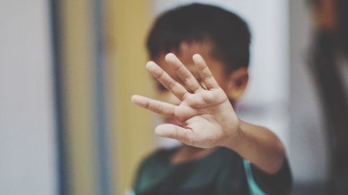 Close-up of boy gesturing stop