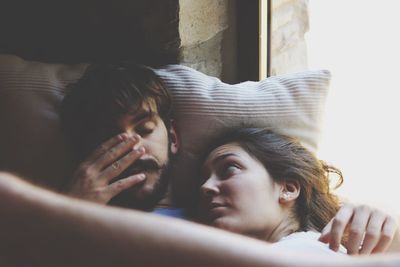 Close-up of couple lying on sofa at home