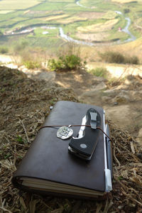 High angle view of penknife with diary on field