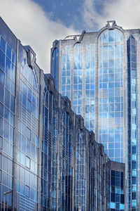 Low angle view of modern glass building against sky