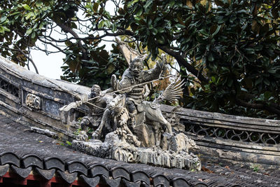 Low angle view of statue against trees