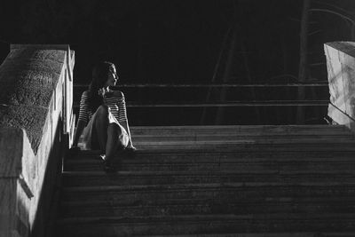 Low angle view of woman sitting on staircase