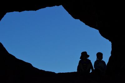 Silhouette of two men against clear sky