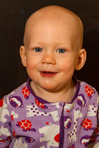 Close-up portrait of baby boy against black background