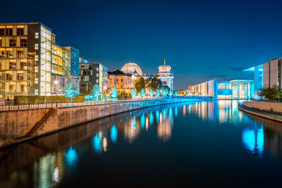 Panoramic view of canal amidst buildings in city at dusk