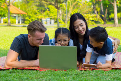 Happy family using laptop at park