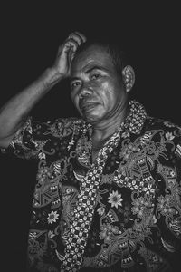 Portrait of man wearing mask against black background