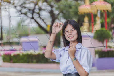 Portrait of school girl standing behind volleyball net