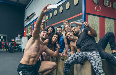 Friends taking selfie sitting at gym