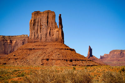 Low angle view of landscape against clear blue sky