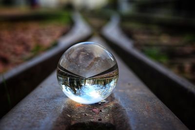 Close-up of crystal ball on metal railing
