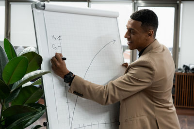 Side view of man using mobile phone in office