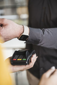 Businessman paying with smart watch on card reader machine